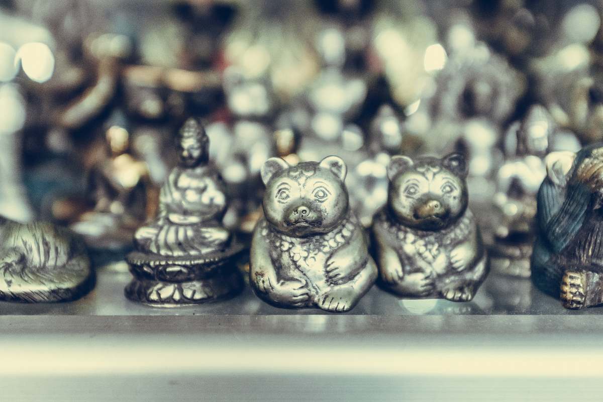 art close-up photography of silver-colored bear and Buddha figurines ubud