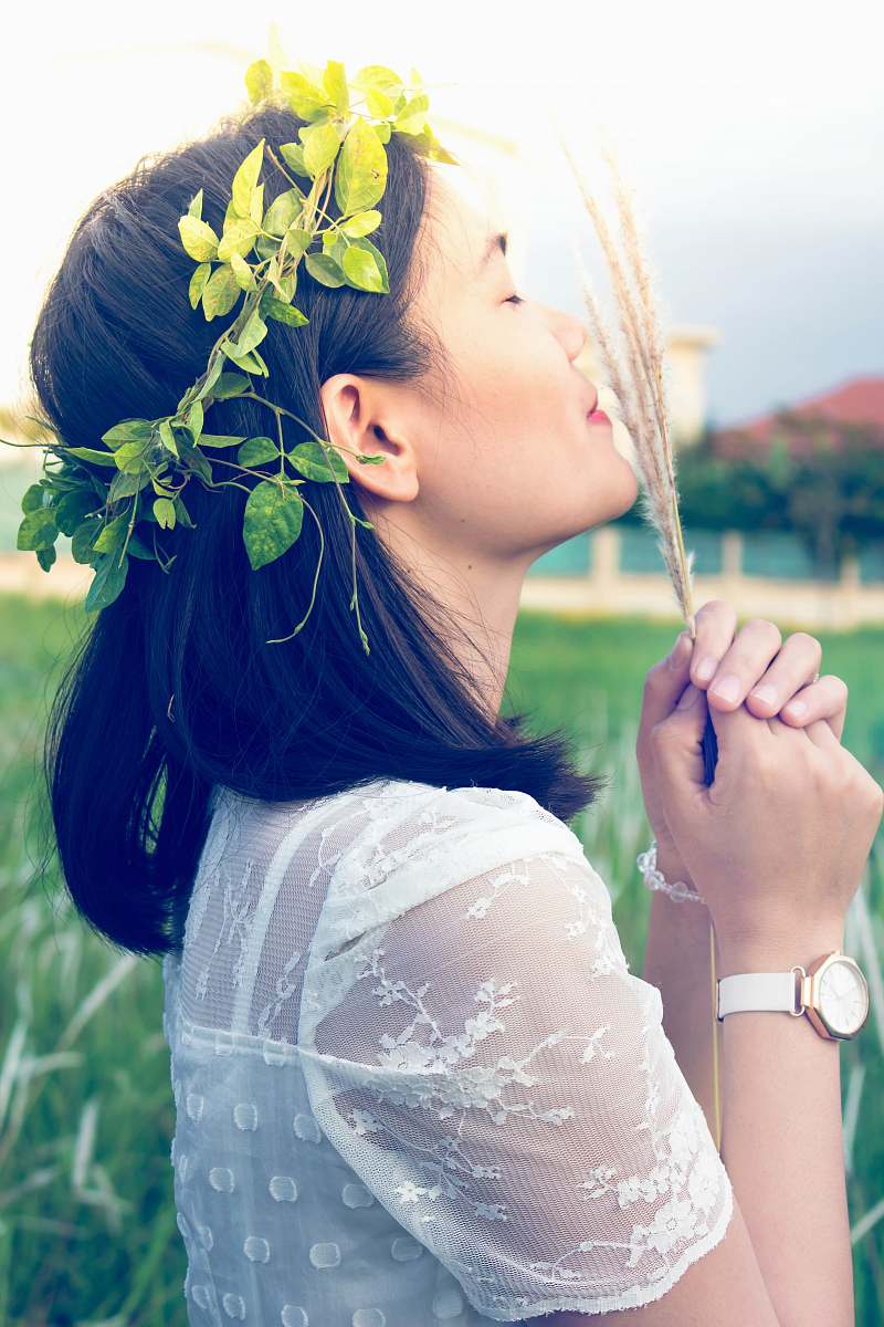human close photography of woman holding fern woman
