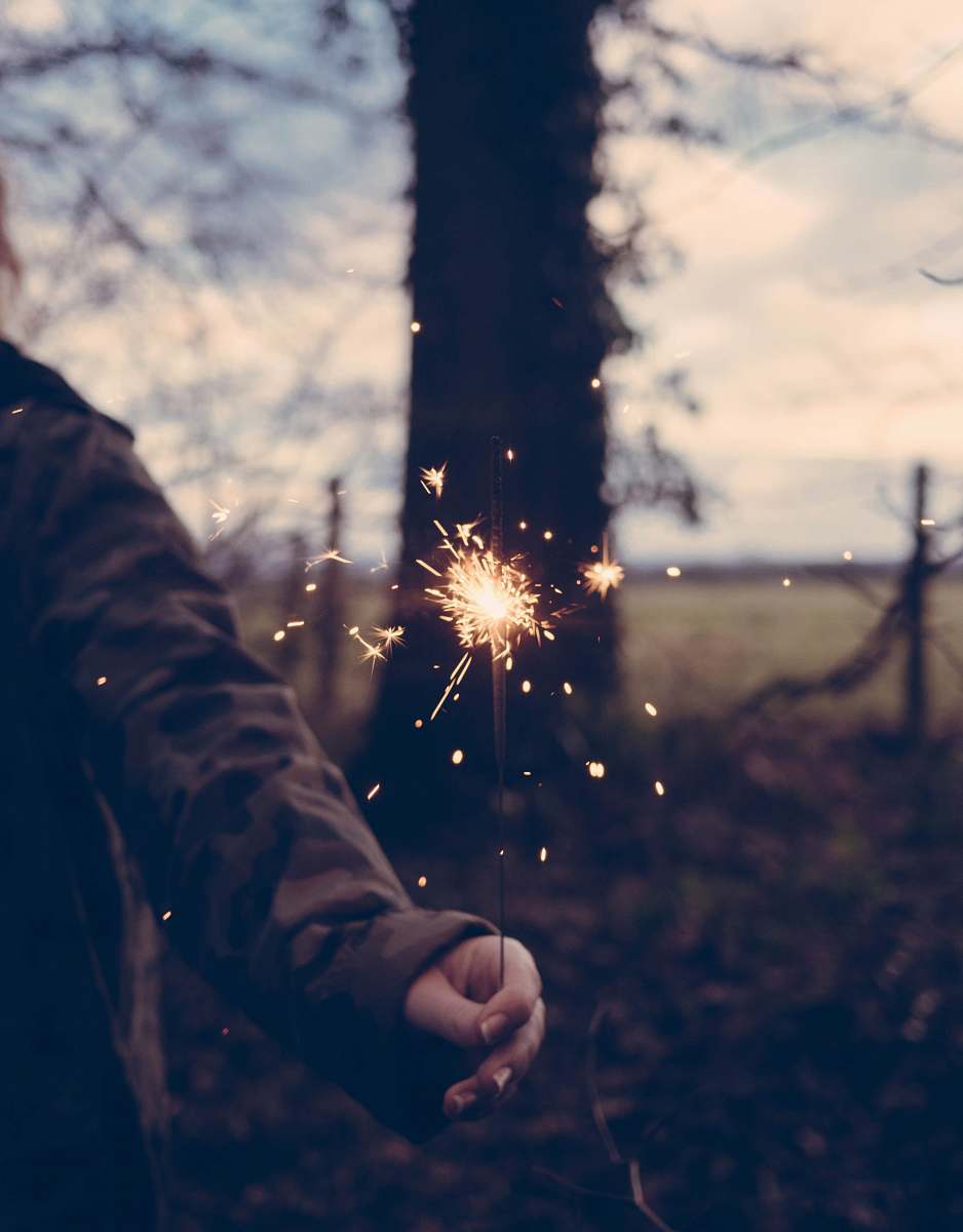 human person holding sparkler at daytime person
