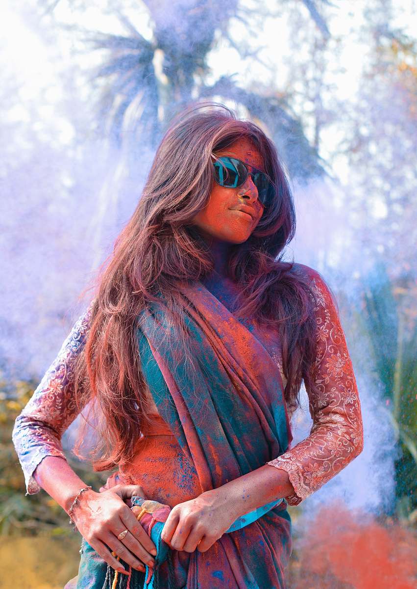 human selective focus photo of woman wearing green and brown shawl covered with powder person
