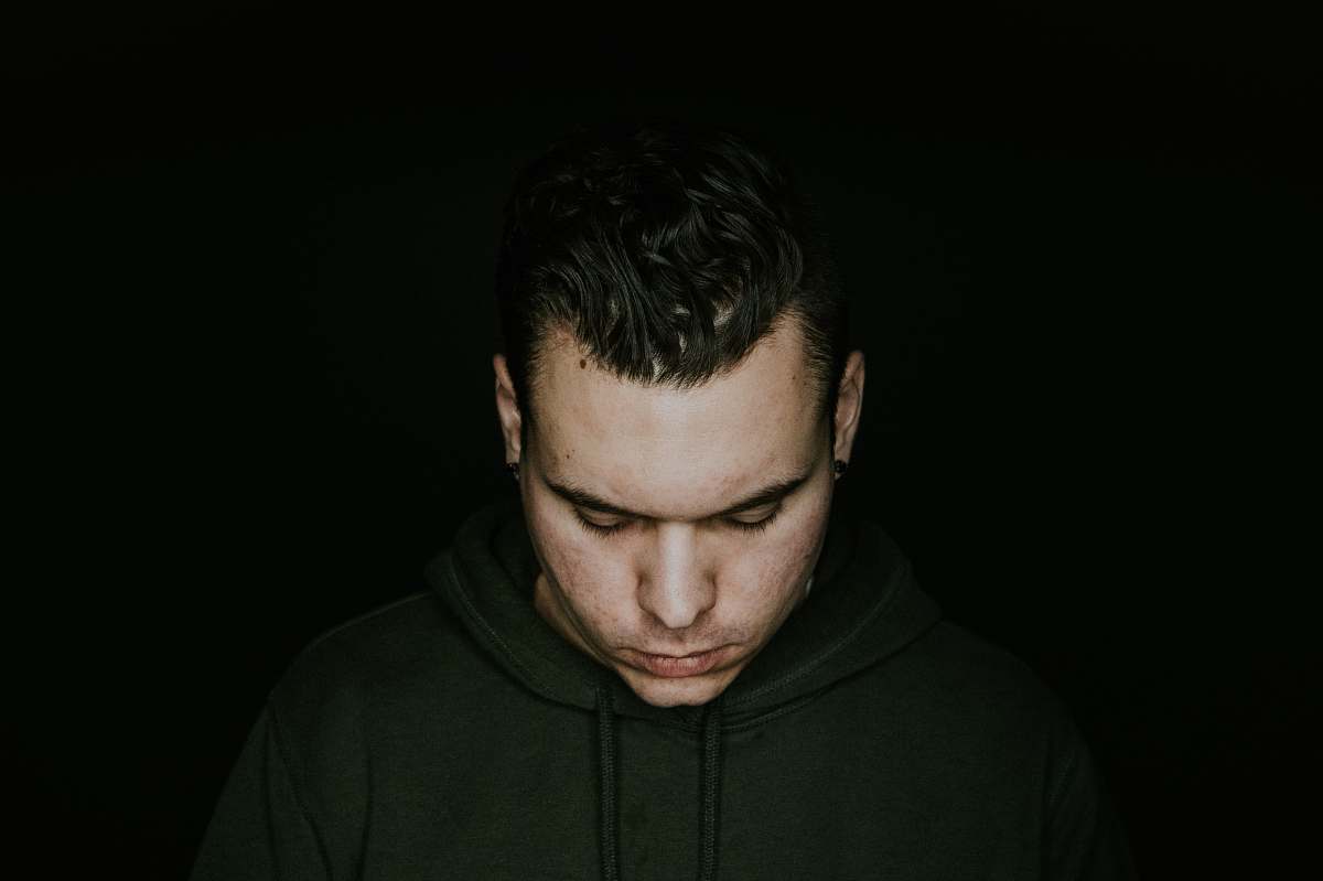human man in green pullover hoodie looking down people