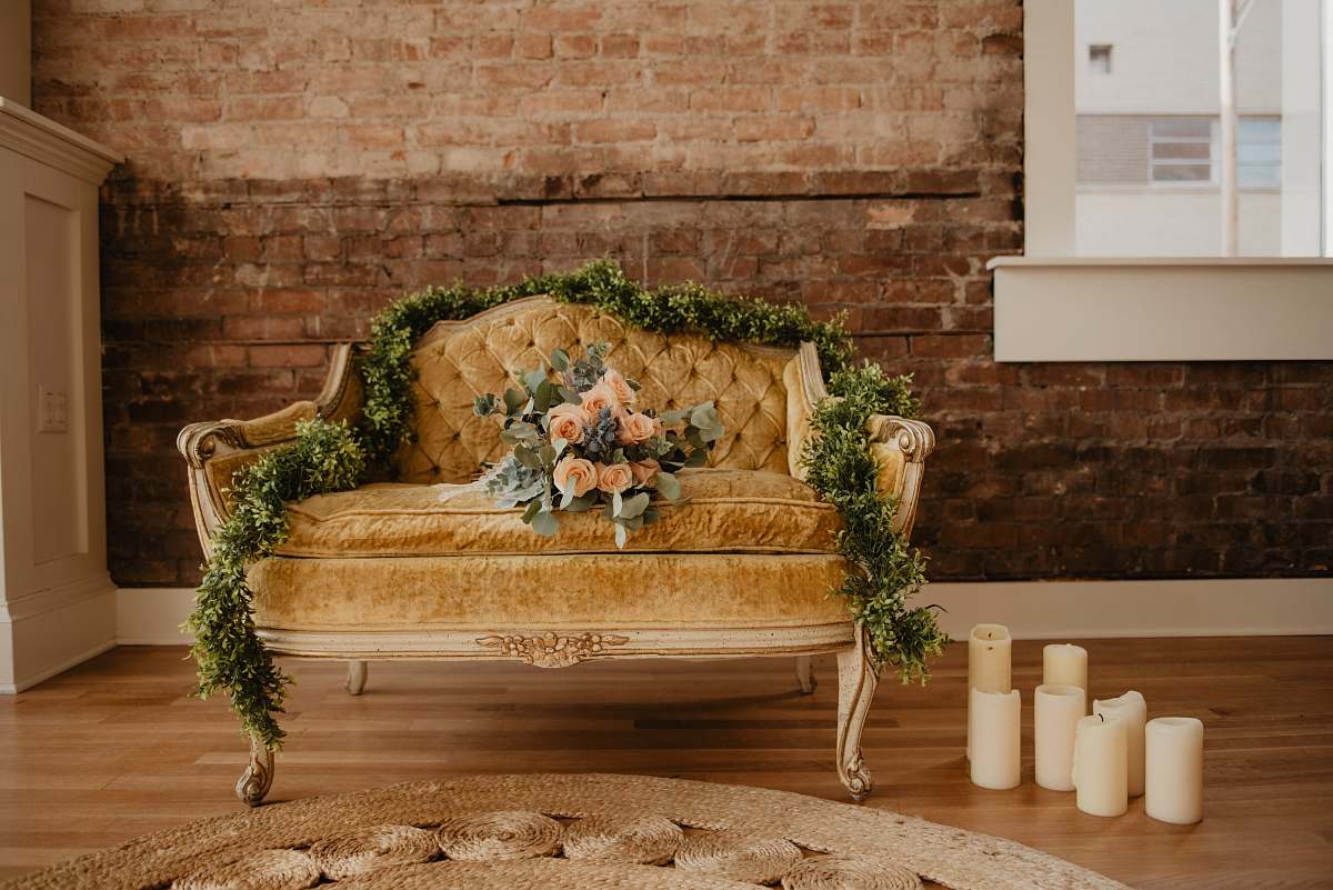furniture vacant tufted beige loveseat with bouquet of orange rose flowers couch