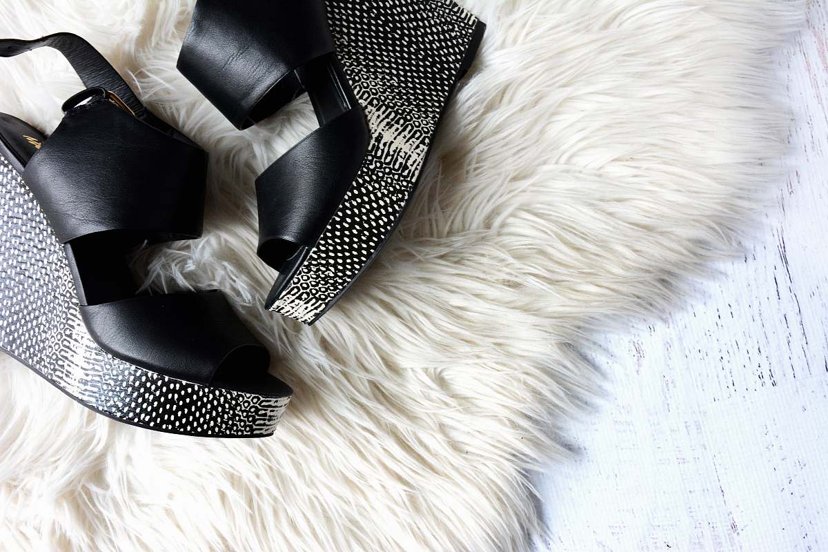 fashion pair of women's black-and-gray wedges on white fur textile shoe