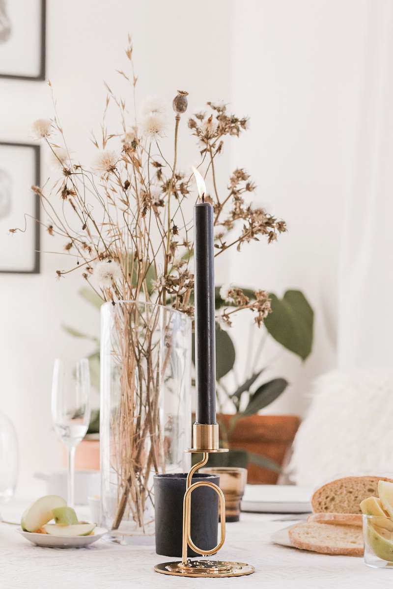 glasses black and gold candle stick on white wooden table glass