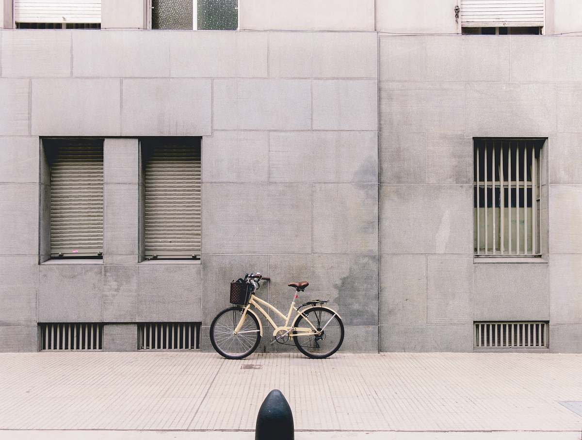 grey person taking photo of white parked bicycle buenos aires