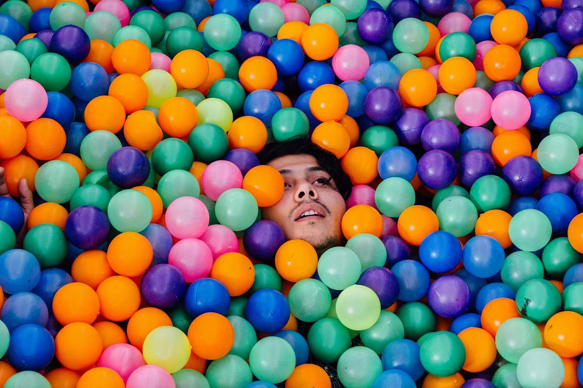 man man lying in ball pit balloon
