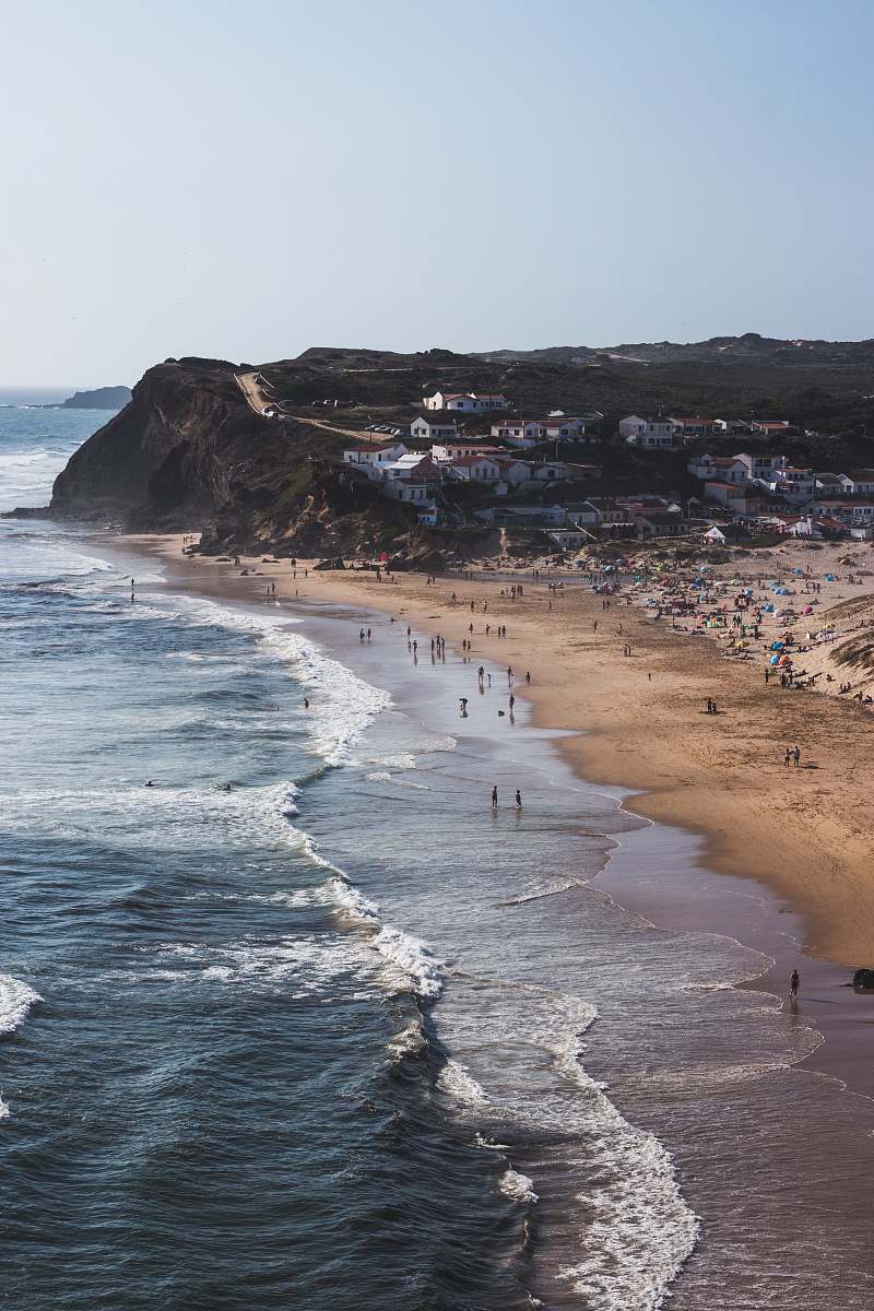 nature group of people walking on shore beside body of water ocean