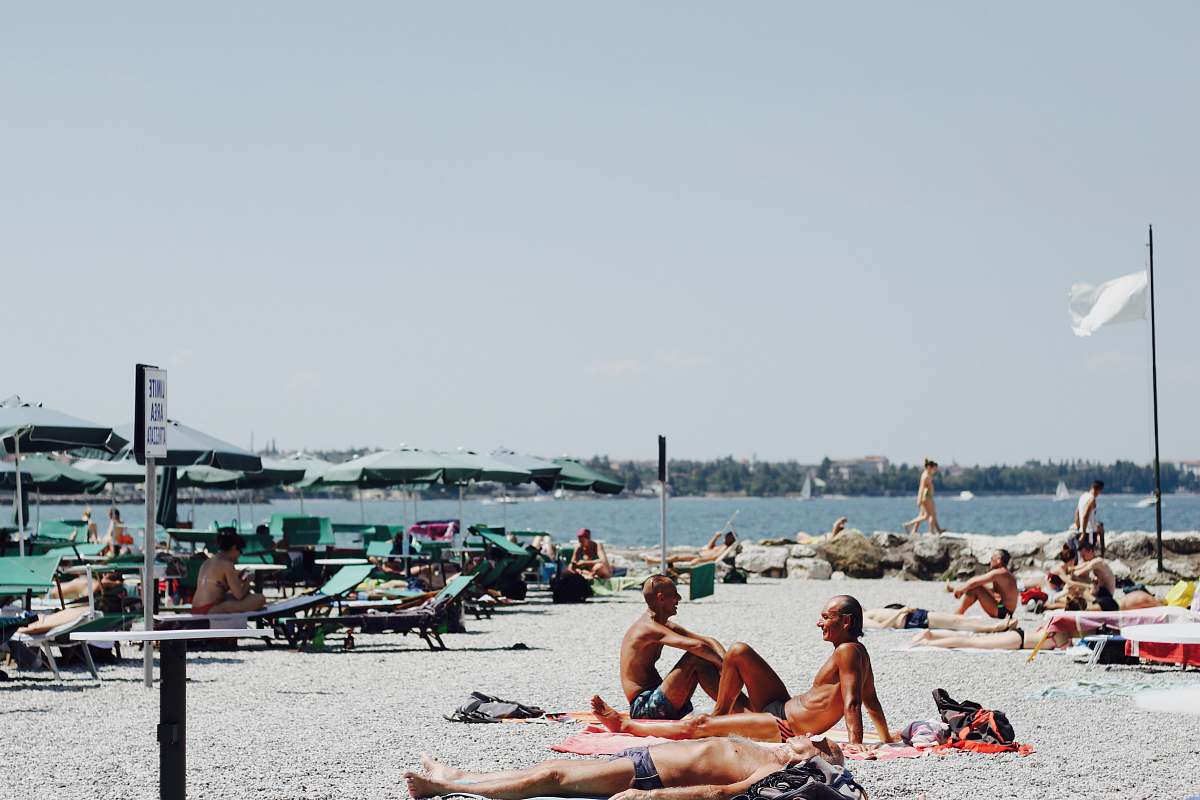 coast people on beach during daytime ocean