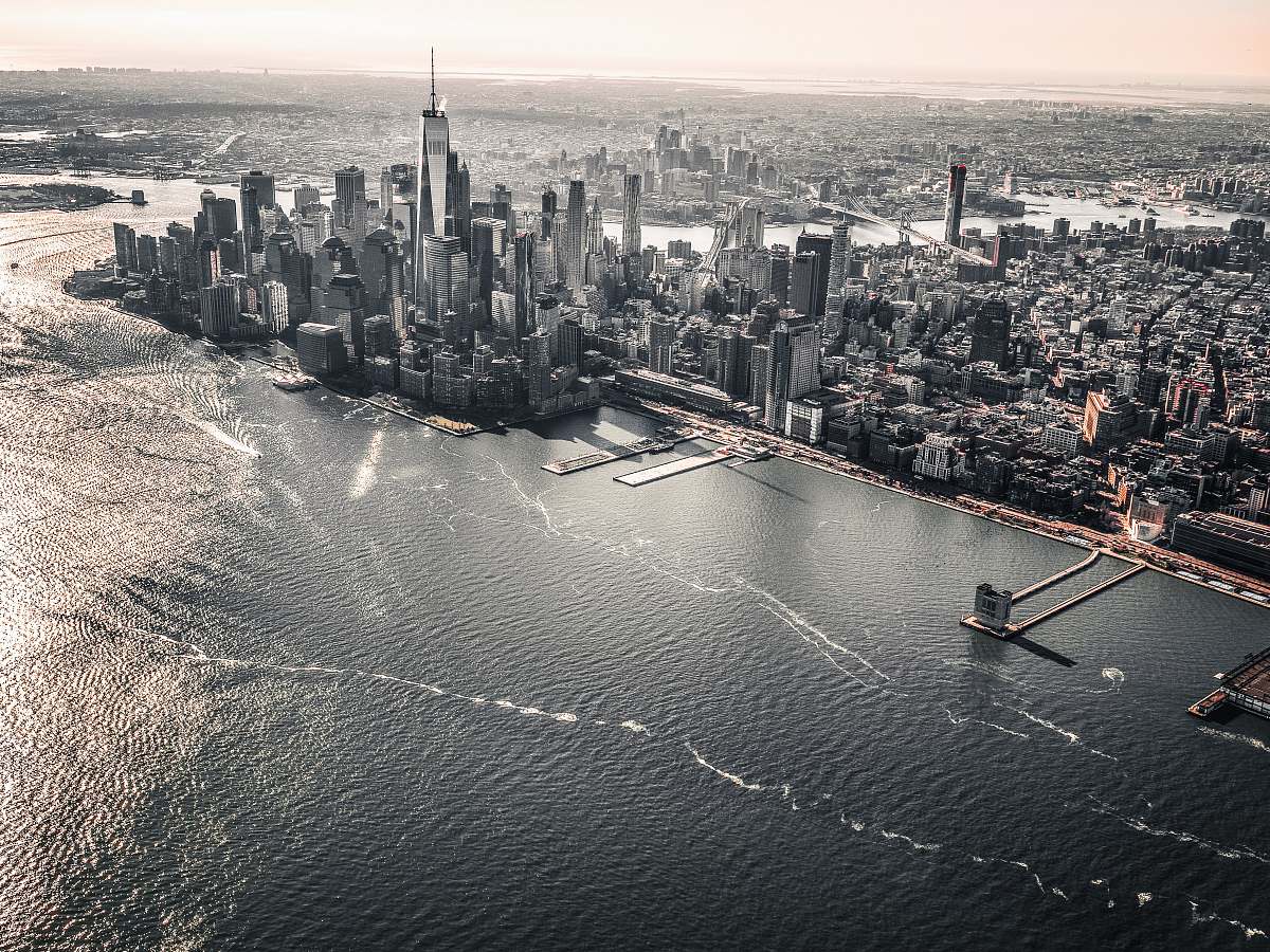 city aerial photography of large body of water across city with high-rise buildings at daytime grey