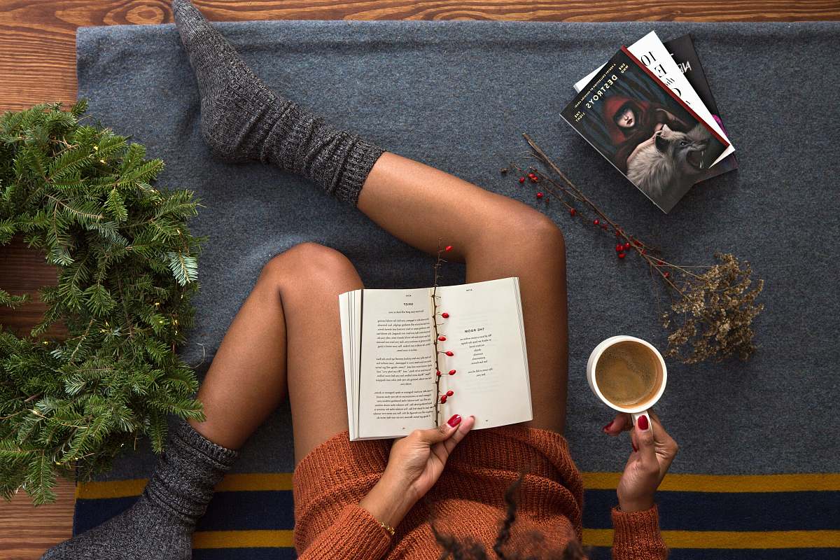 reading opened book on person's lap with gray socks book