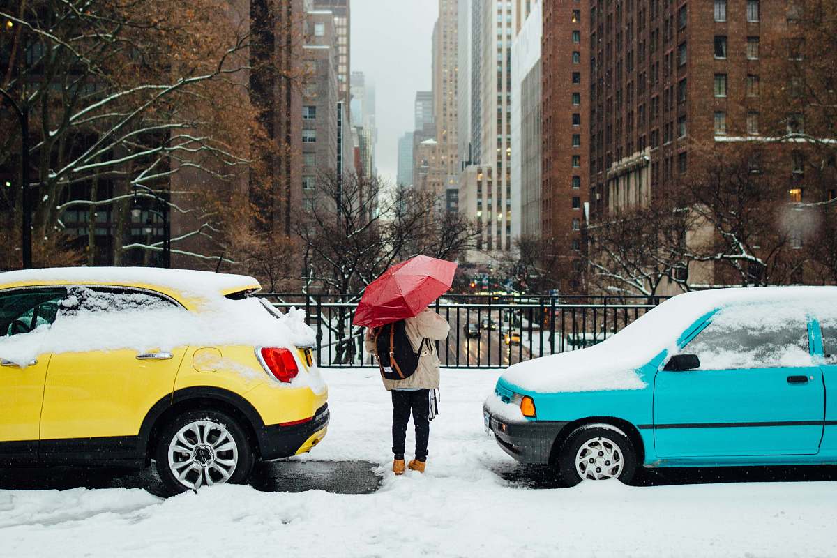 person person standing in between two cars umbrella