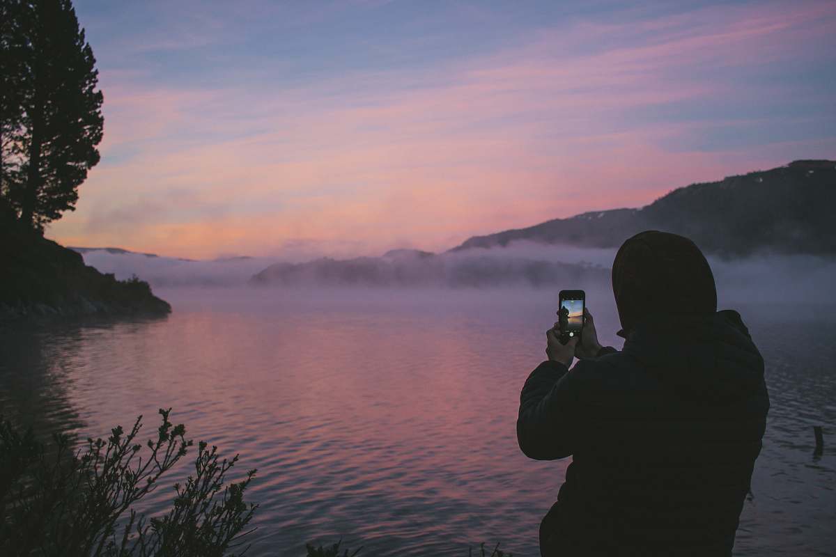 person person taking photo of foggy river people