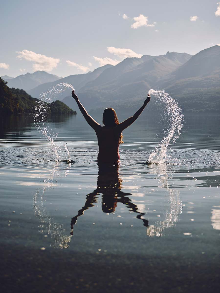 person woman raising her two hands with splashing water people