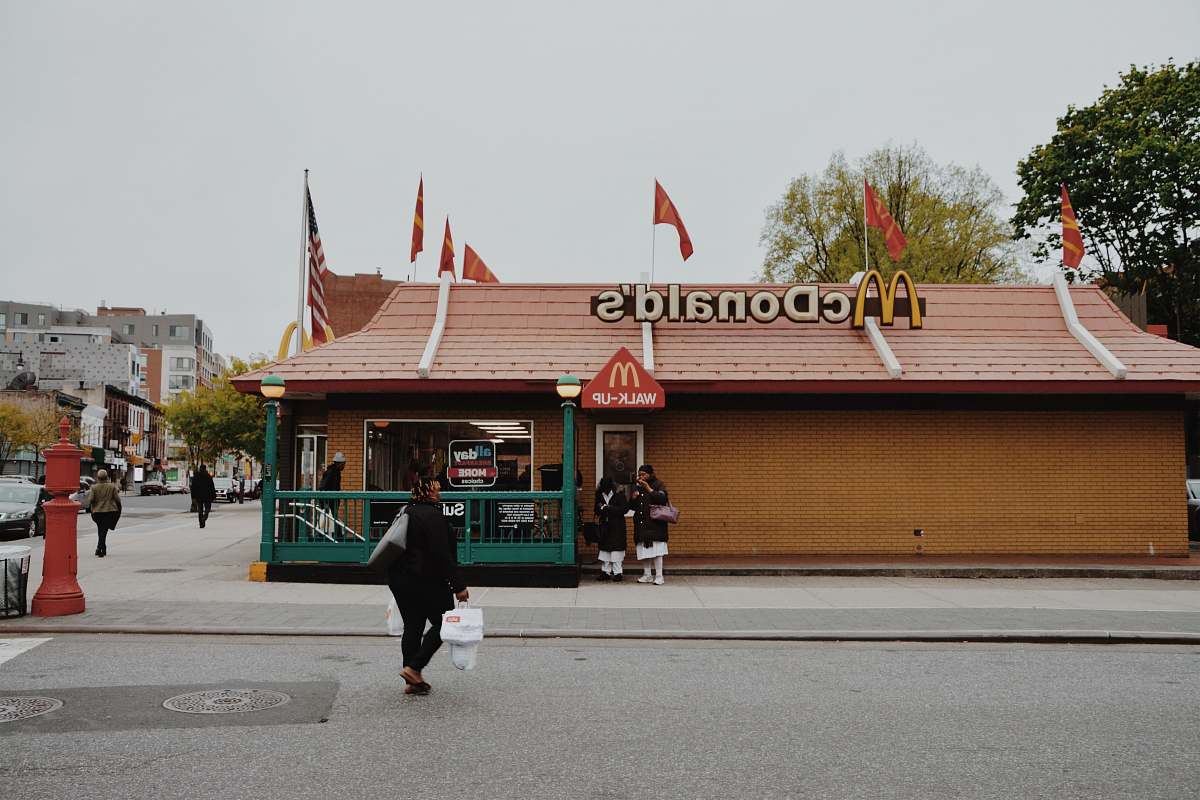 person woman walking towards McDonald's branch during daytime brooklyn