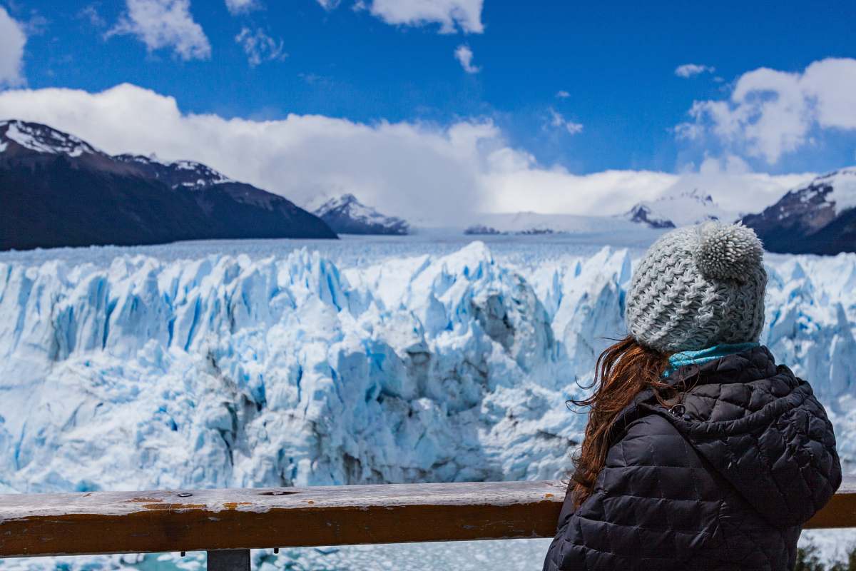 mountain person wearing black hooded jacket seeing snow mountain during daytime snow