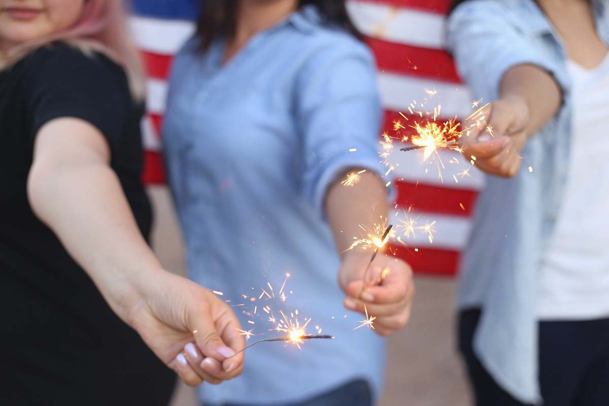 human three person holding sparklers person