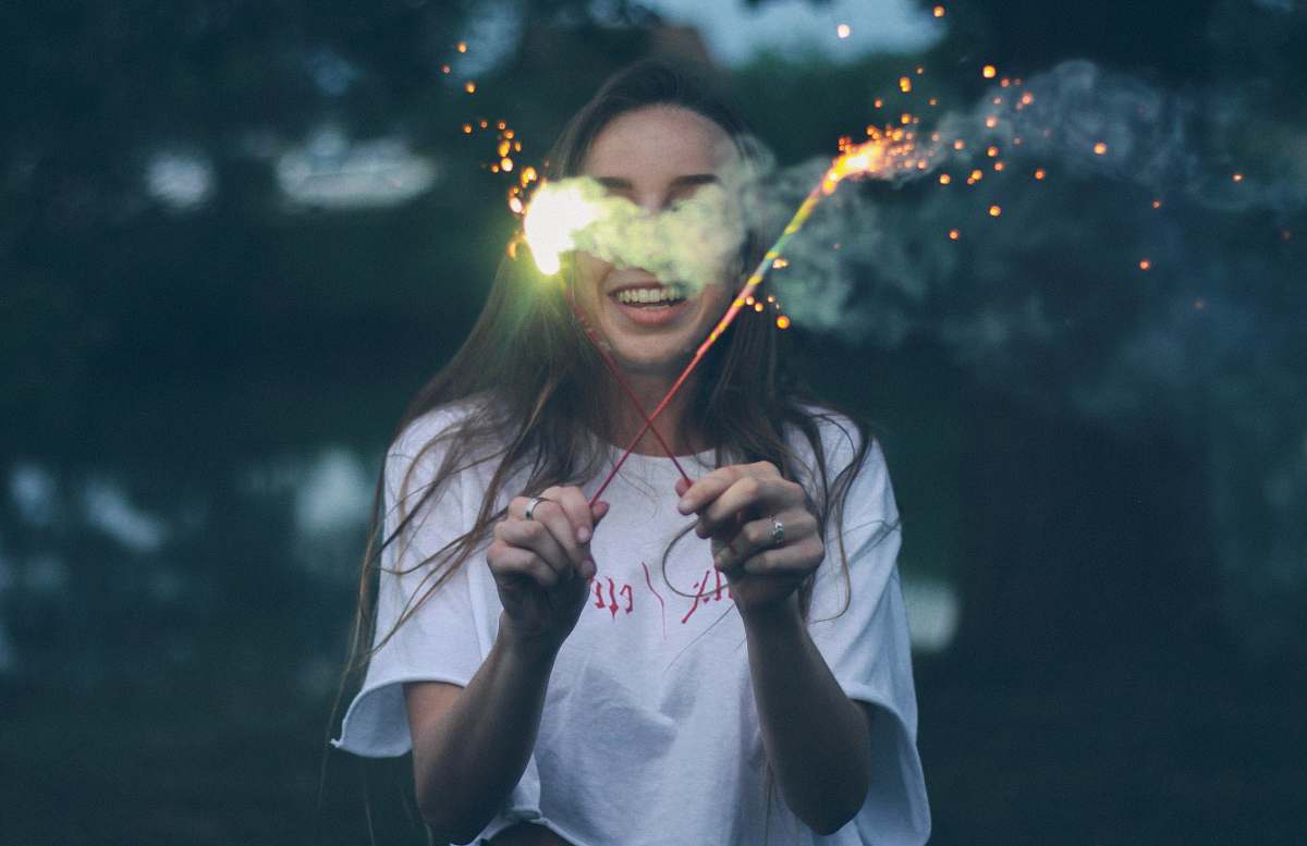human woman holding two sparklers person