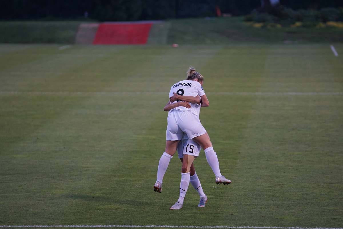 person woman hugging her co player on green field human