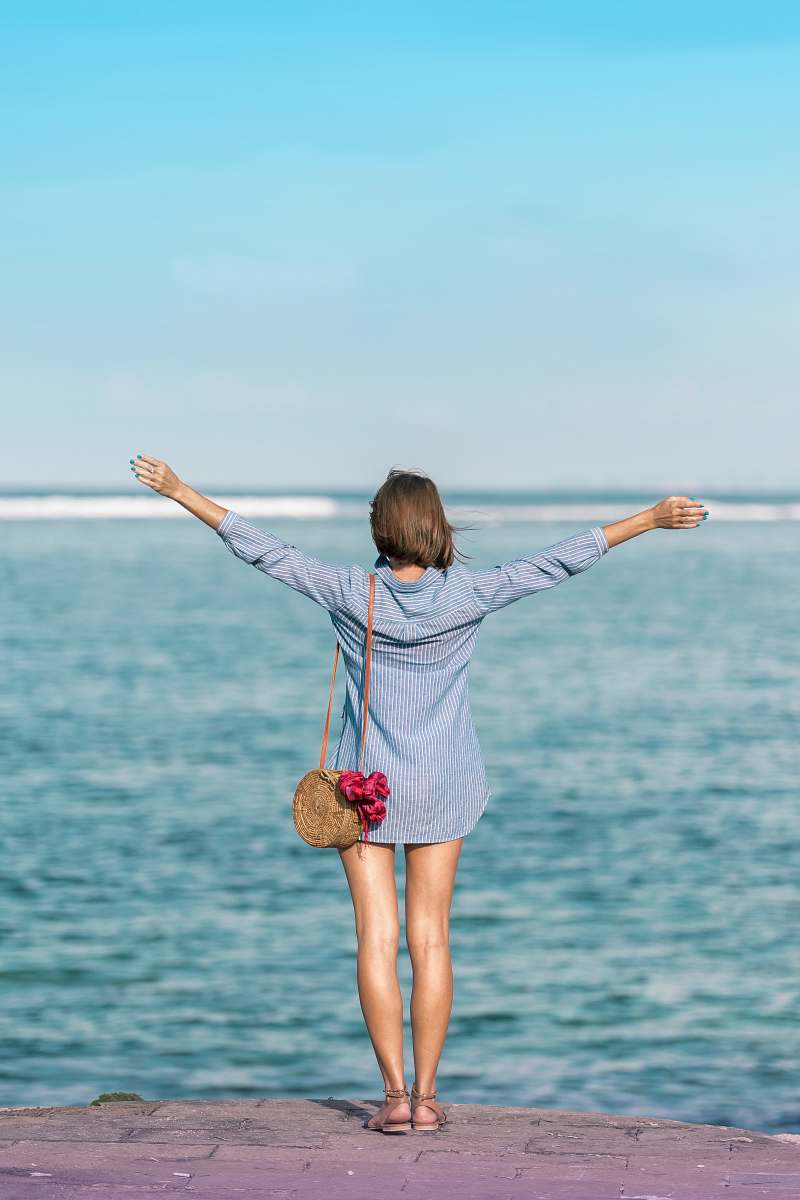 human woman spreading hands standing near body of water person