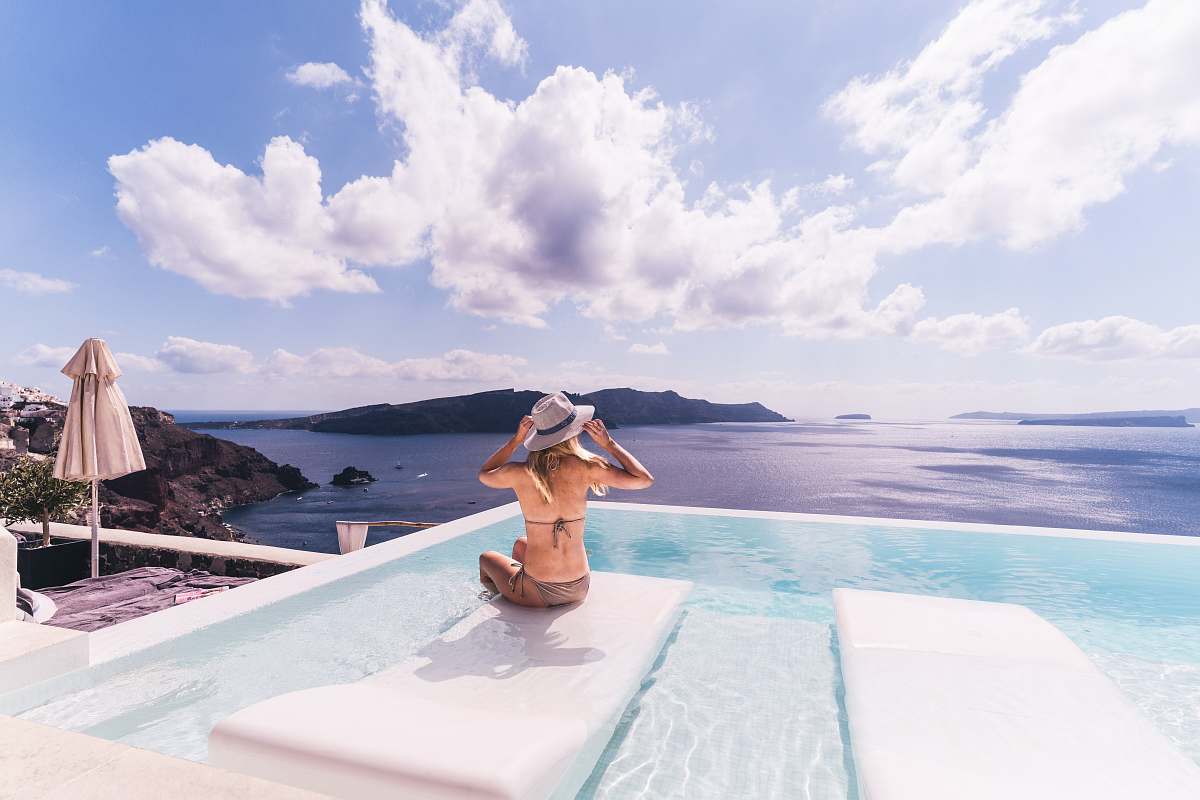 human woman sitting on white chair near body of water during daytime people