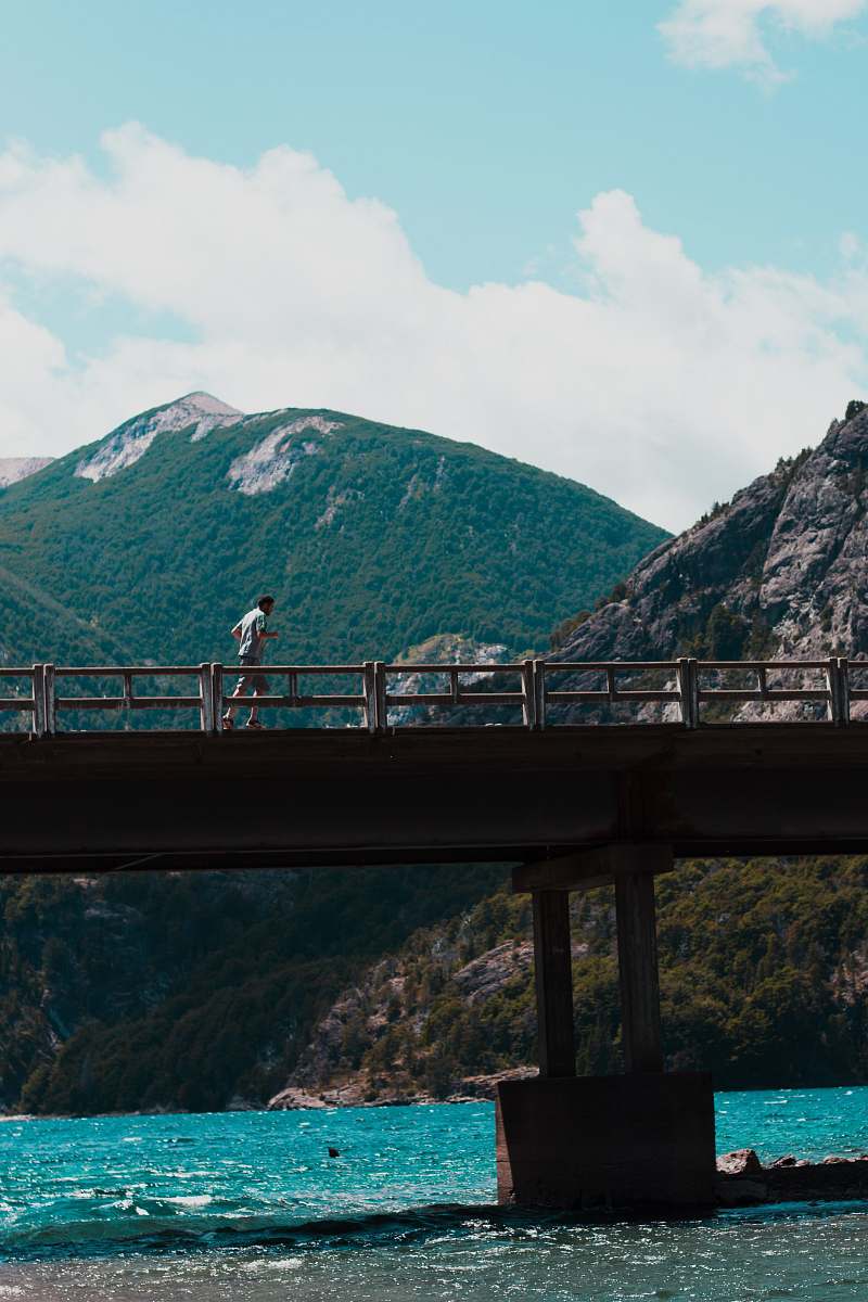 freeway man running on concrete walk bridge above body of water during daytime person