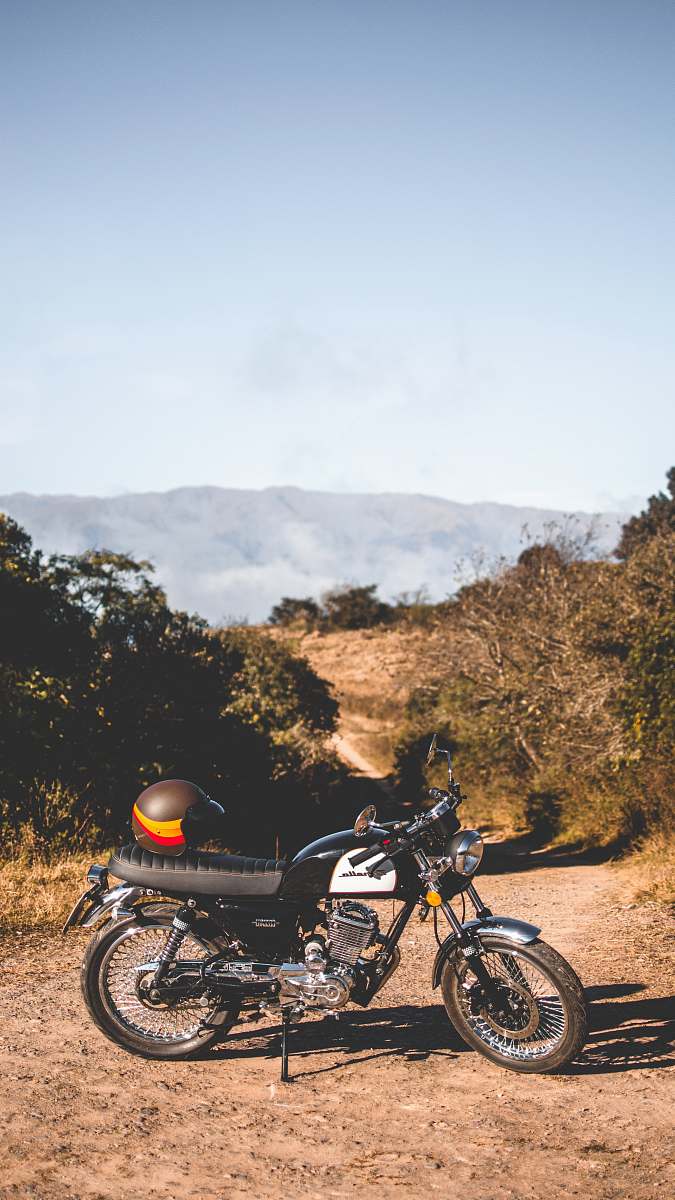 vehicle black and orange helmet on black and white standard motorcycle motorcycle