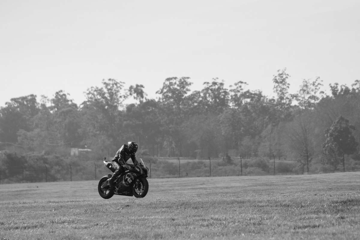 vehicle grayscale photo of man riding sports bike black-and-white