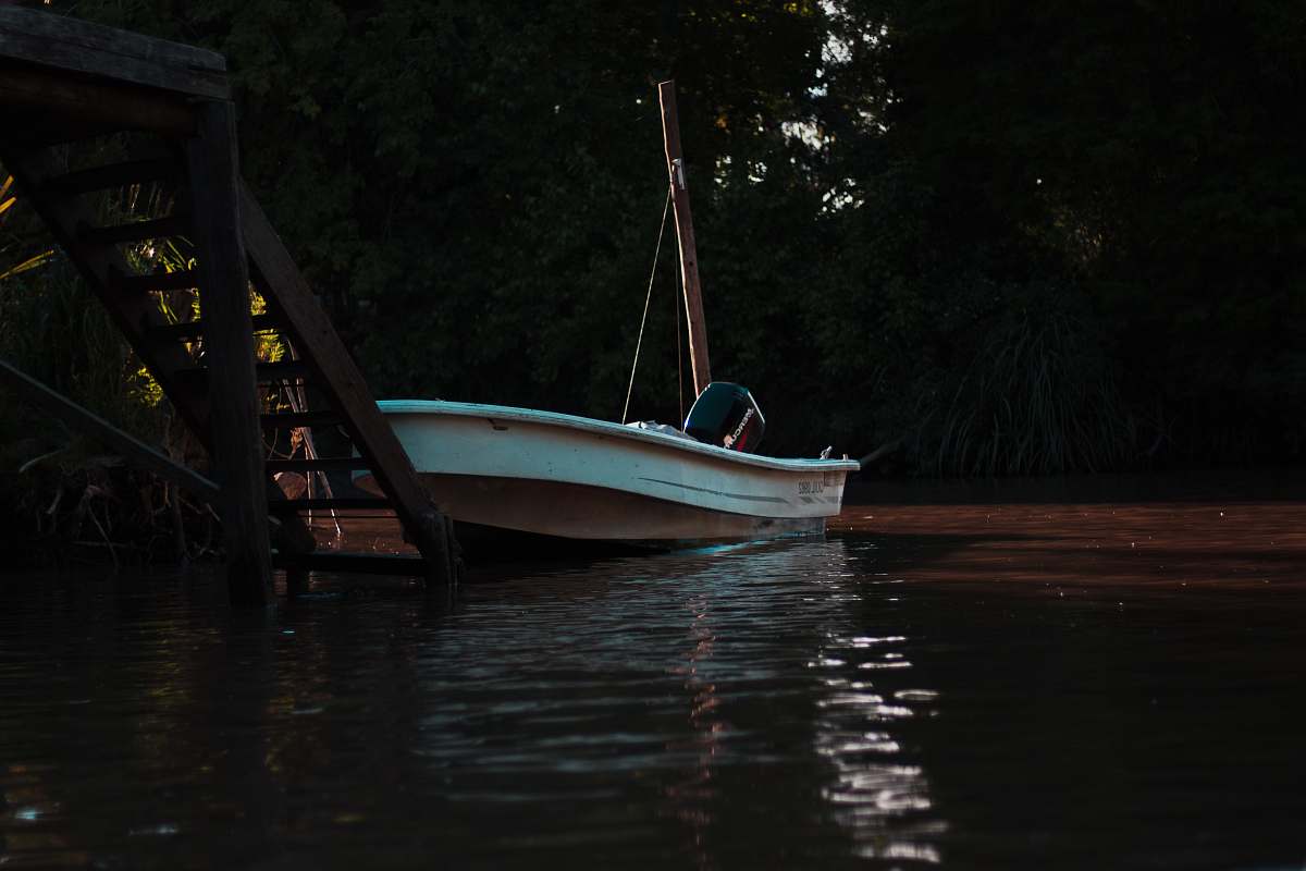 vehicle white boat docked in front of wooden stair during daytime vessel