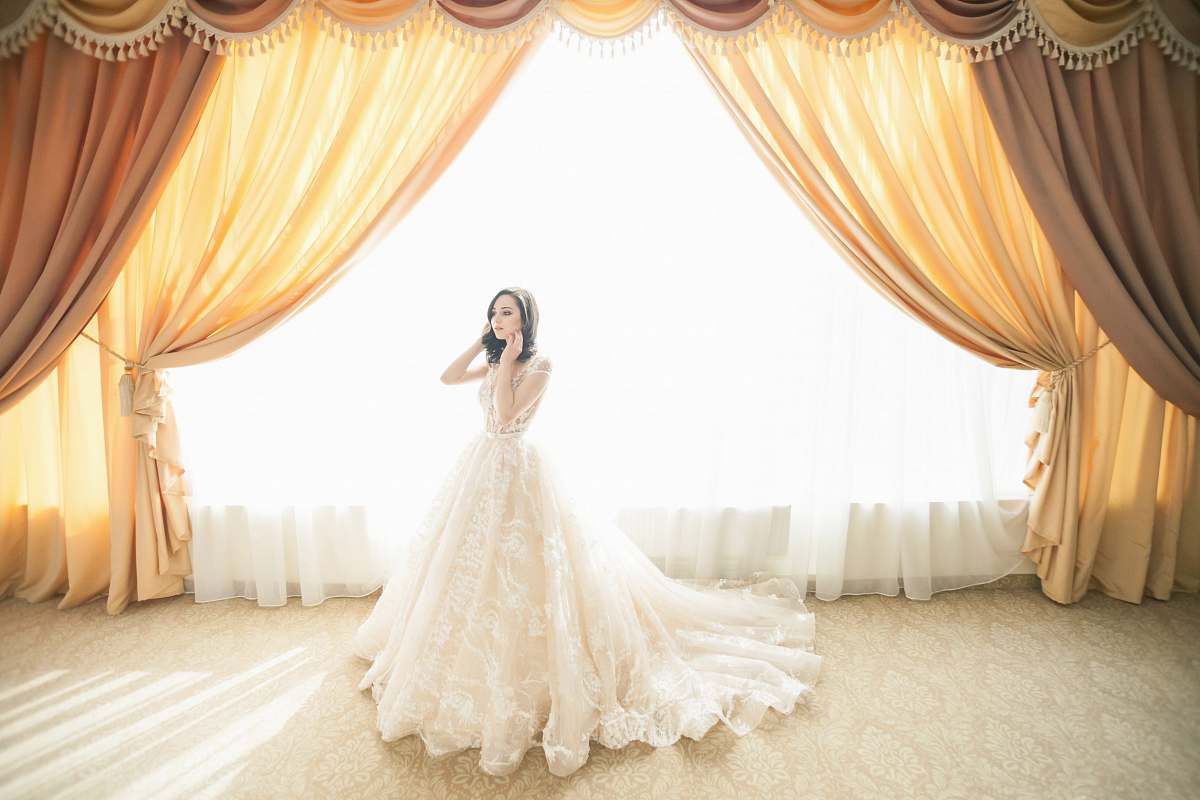 bride photo of woman wearing white gown near window curtain home decor