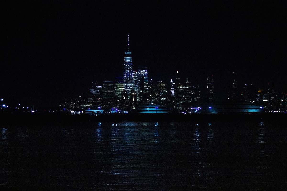architecture aerial photography of city with high-rise buildings near body of water during night time tower