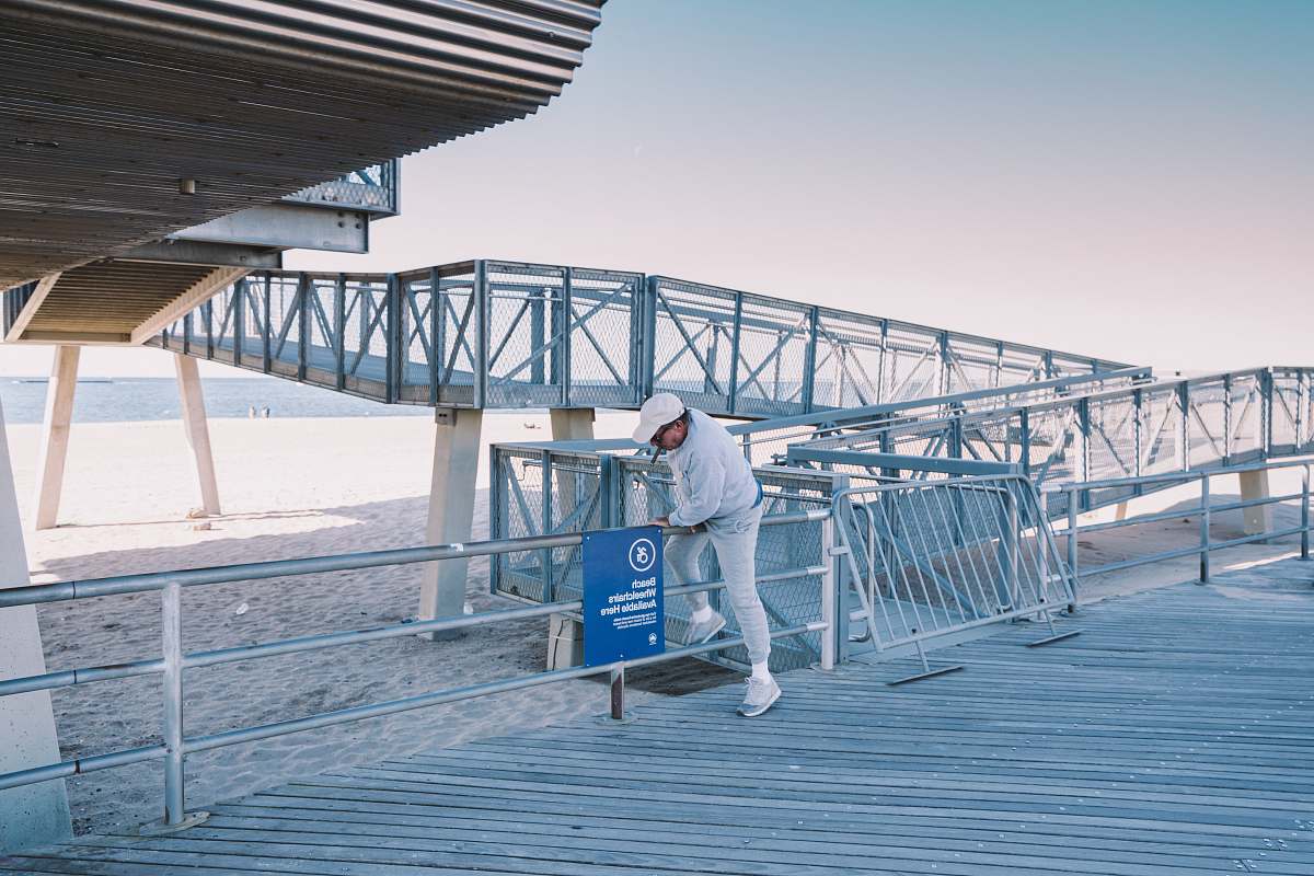 Capture the essence of a serene seaside escape with this striking image of a man walking on a boardwalk. The scene perfectly encapsulates moments of leisure and reflection, making it ideal for travel blogs, lifestyle articles, or promotional materials for coastal tourism. Whether youre illustrating a narrative or enhancing a visual story, this photo evokes a sense of tranquility and connection with nature.