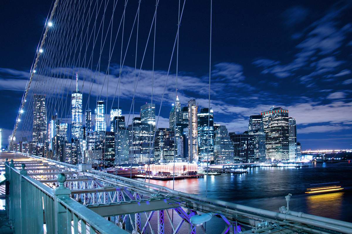 city panoramic photo of buildings through bridge cables town