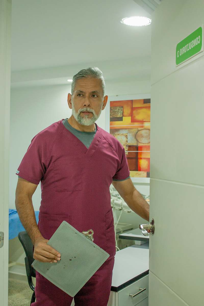 person man in blue crew neck t-shirt standing near white wooden cabinet shelf