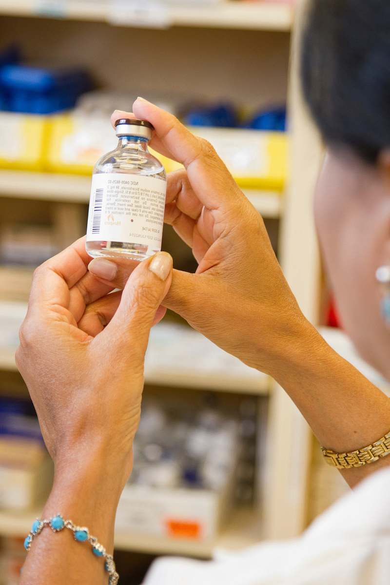 person person holding white labeled bottle cancer drugs