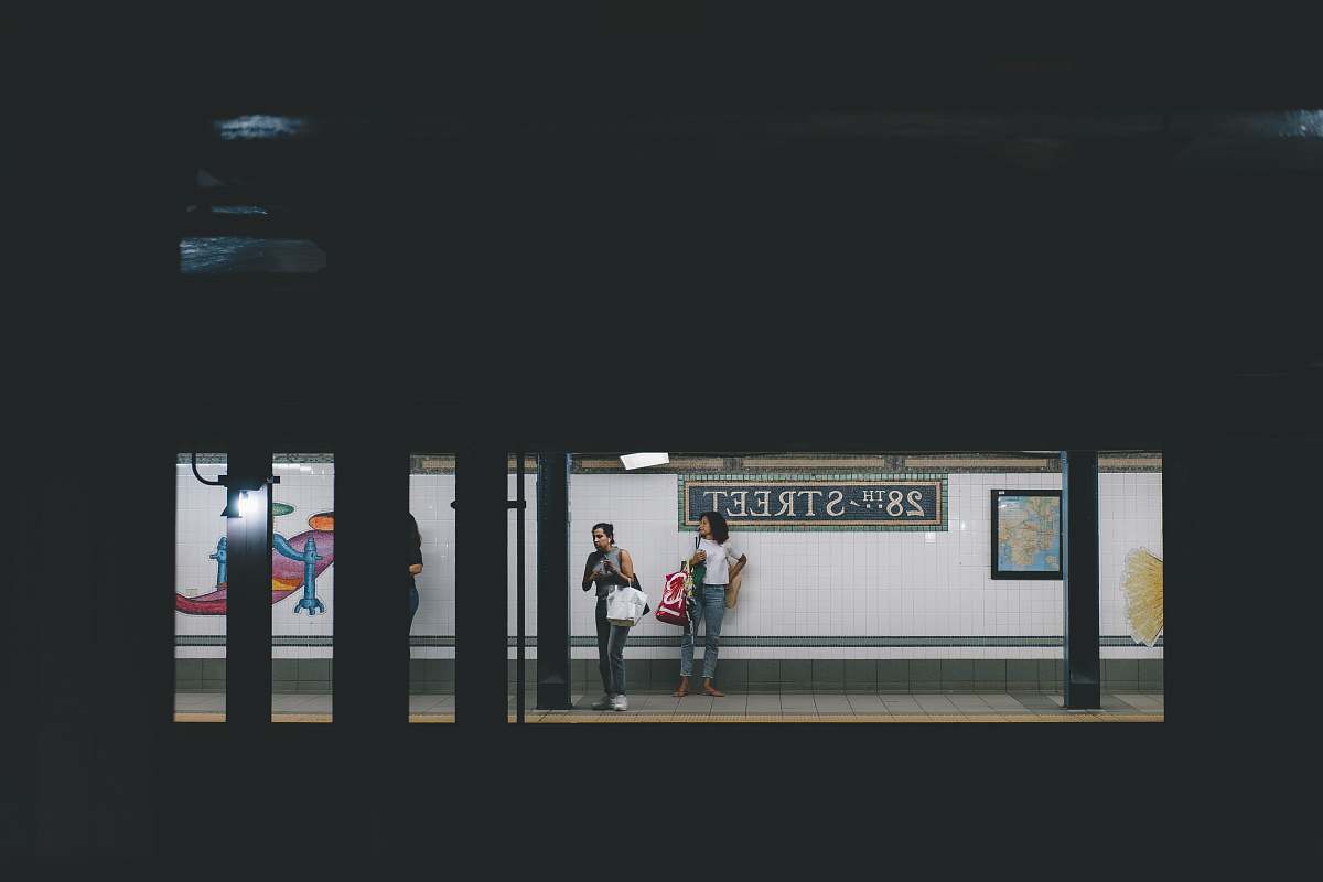 person two women standing on train station train