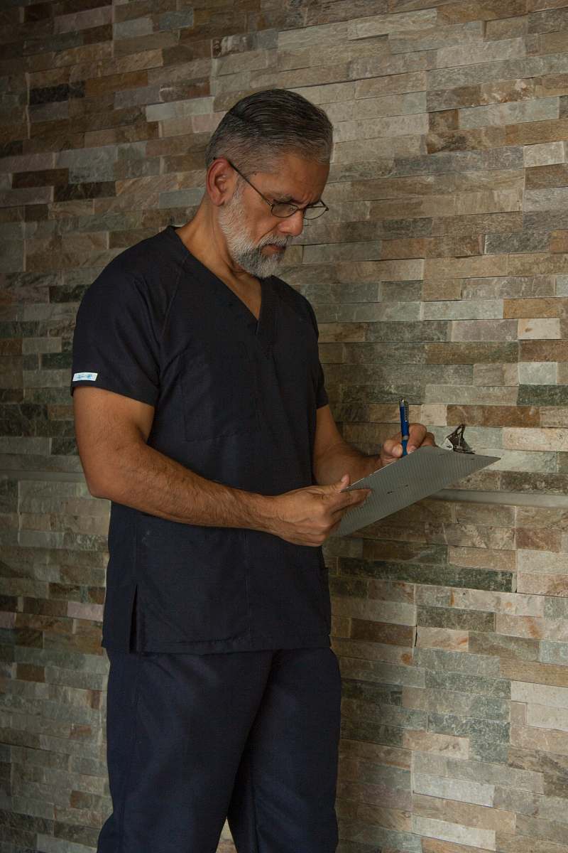 human man in black crew neck t-shirt holding black tablet computer wood