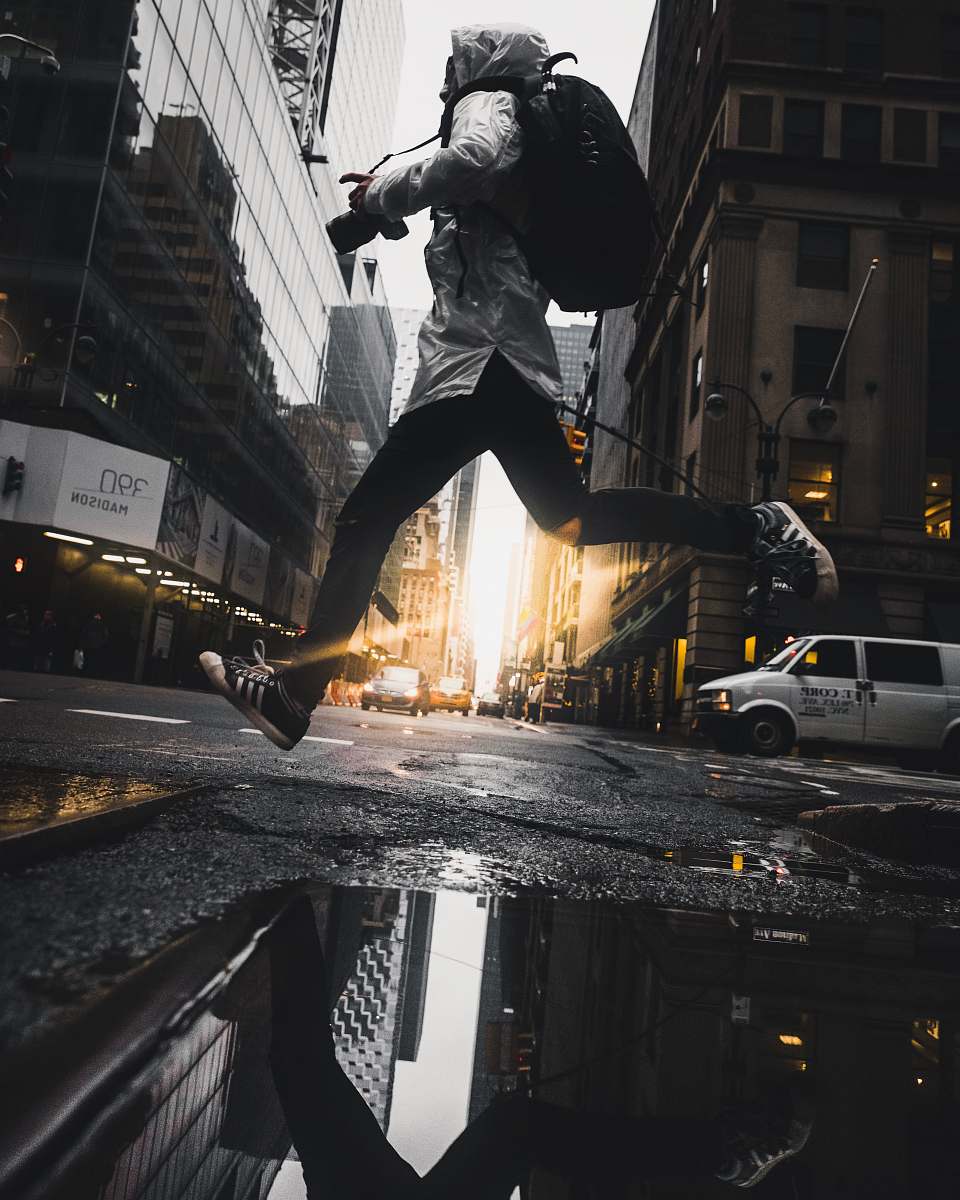 human person jumping above puddle of water people