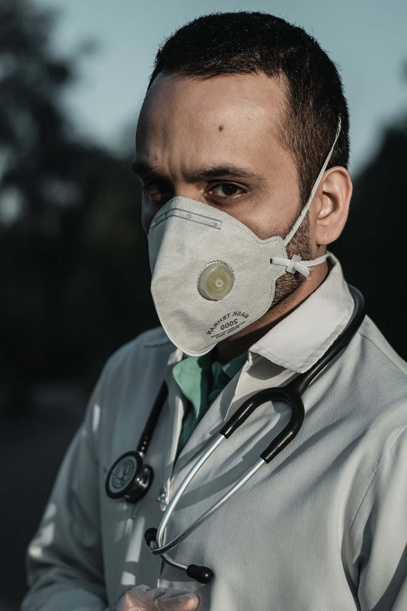human person wearing white and gray gas mask doctor