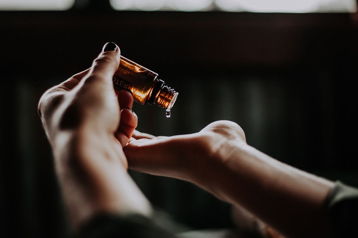person holding amber glass bottle