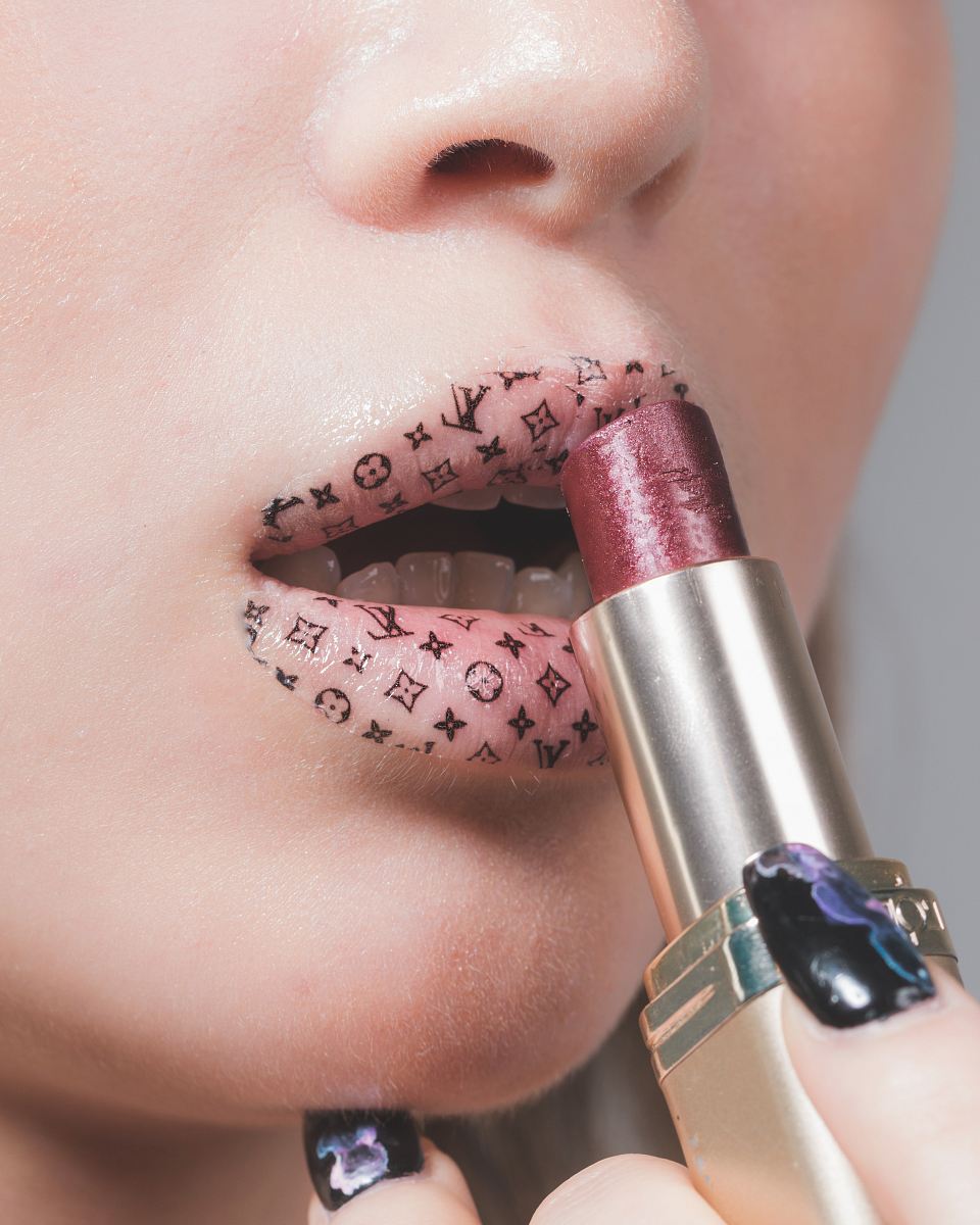 woman putting lipstick on lips