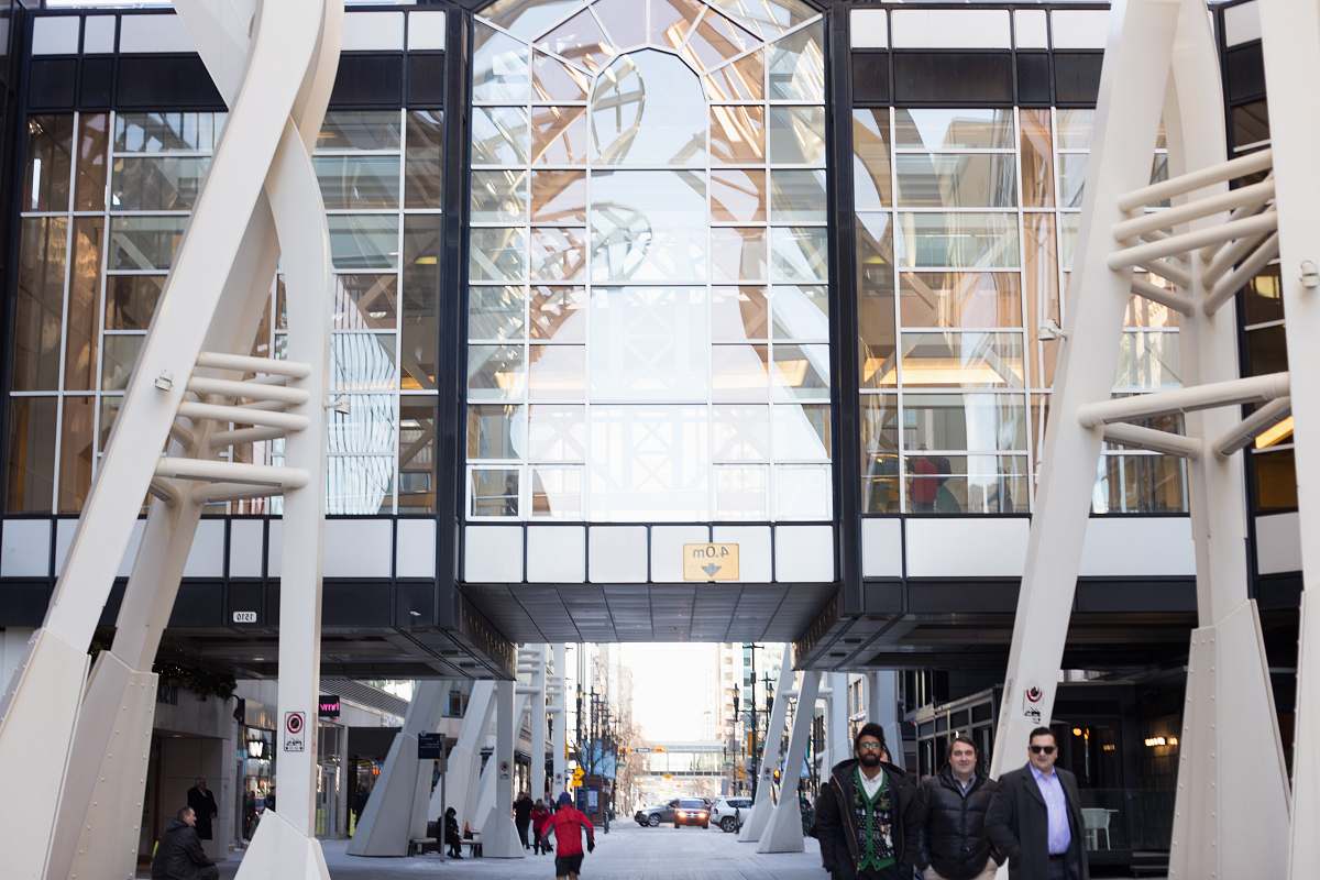 human people walking under glass commercial building person