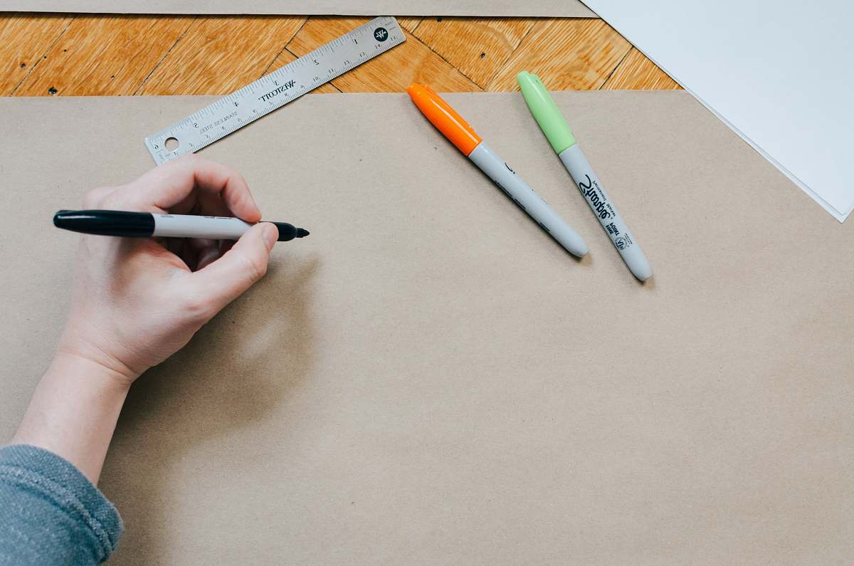 design person holding black marker pen draw