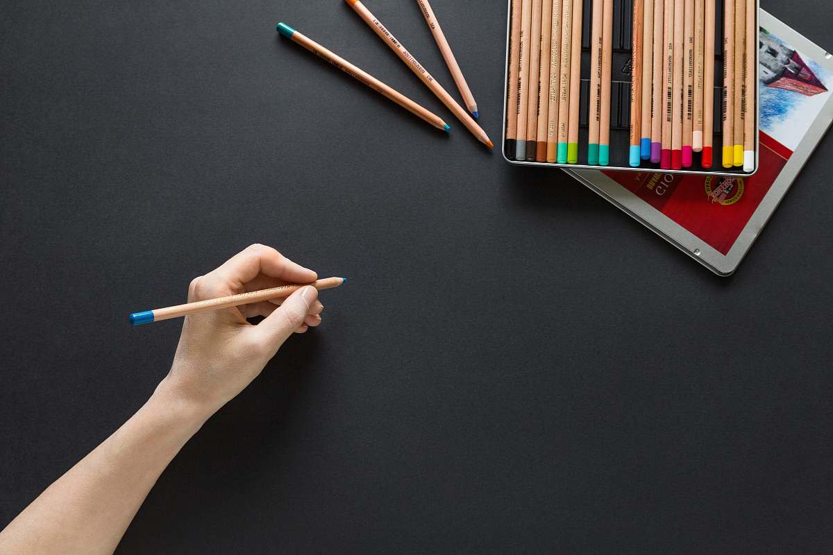 background person holding brown pencil desktop