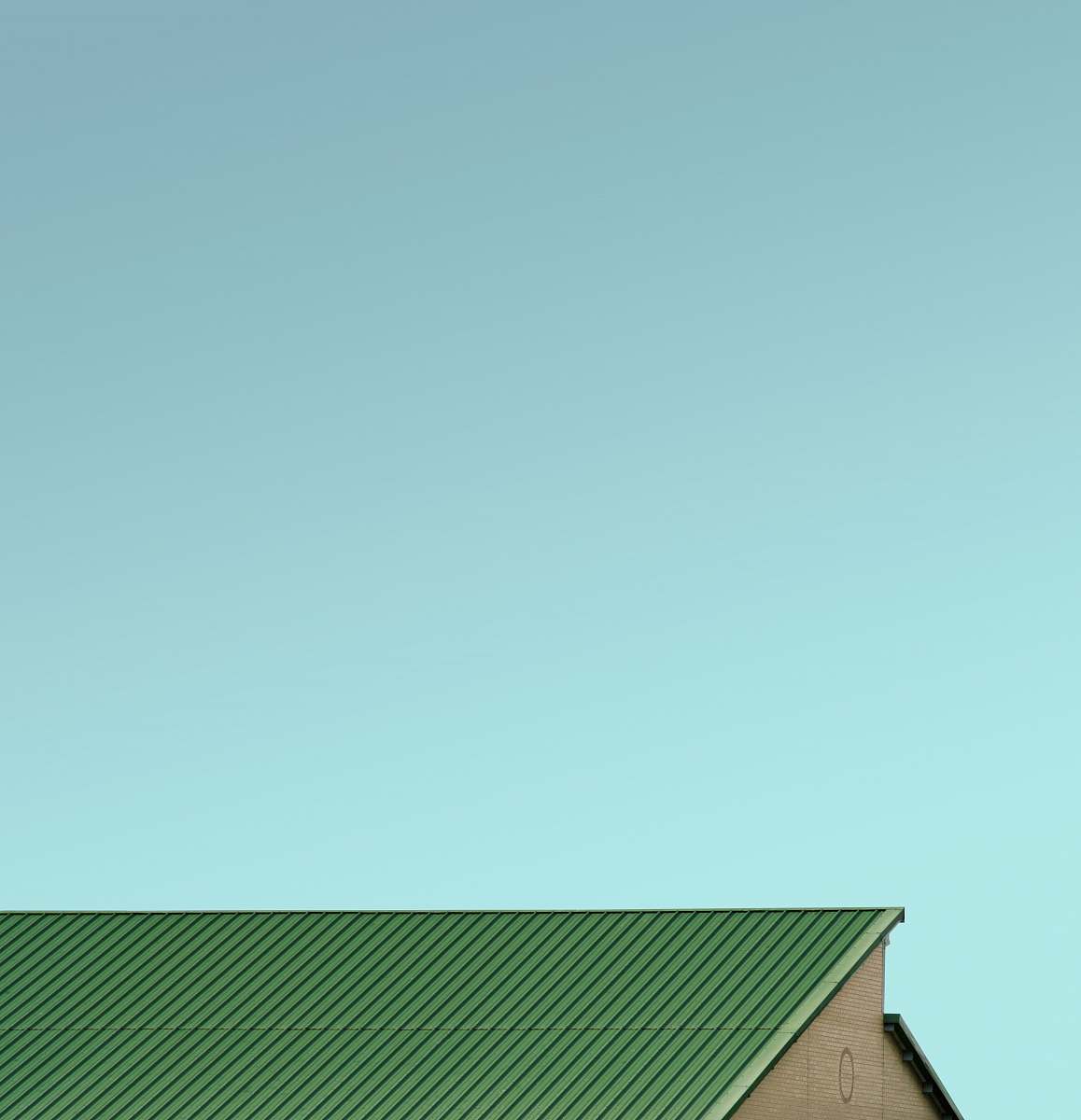 triangle green house roof under blue sky slough