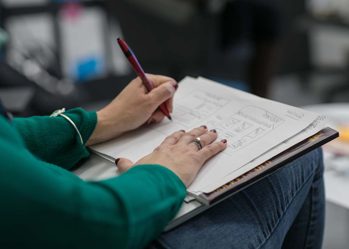 text person writing on paper at lap human