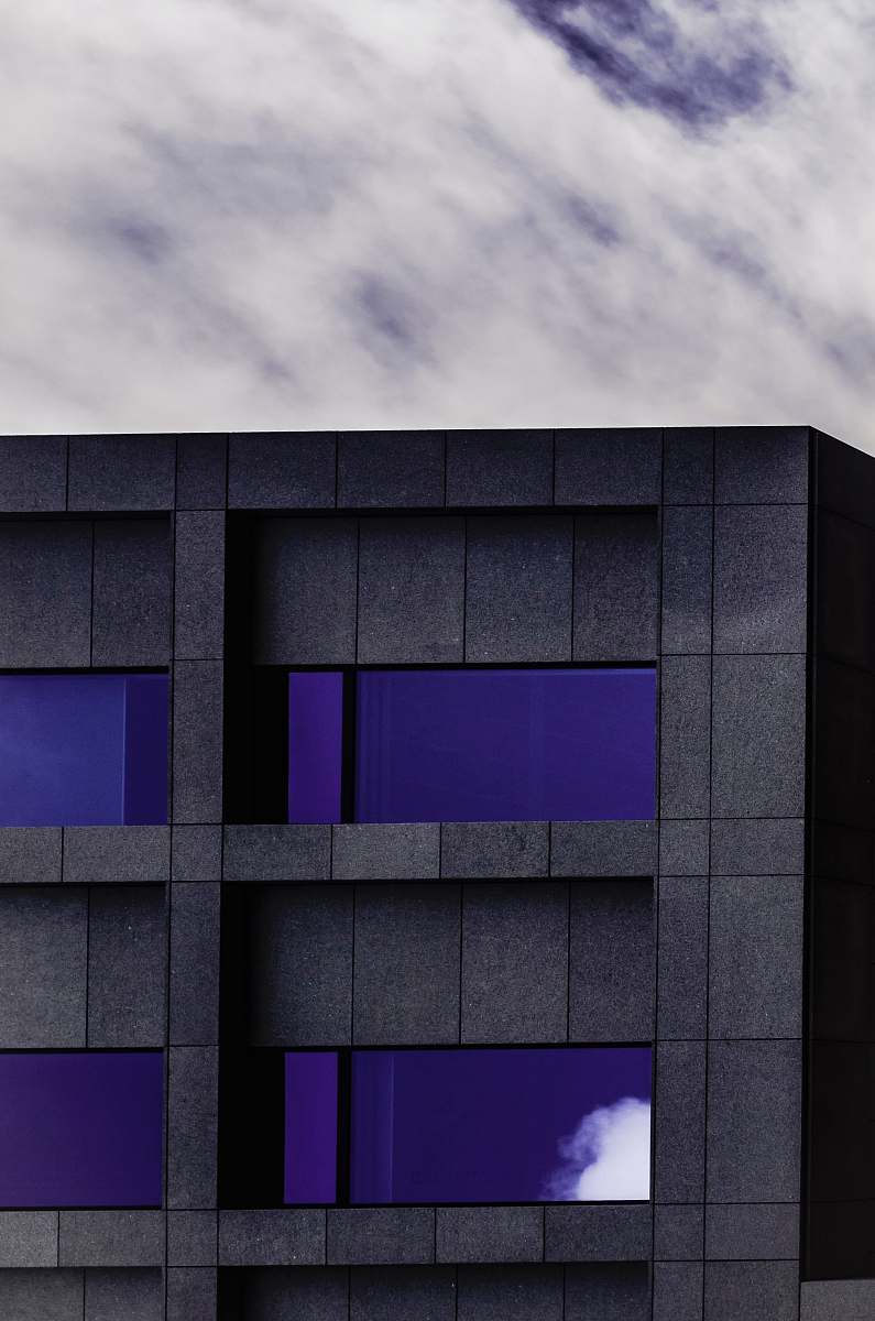 wall gray and purple concrete building under cloudy skyt city
