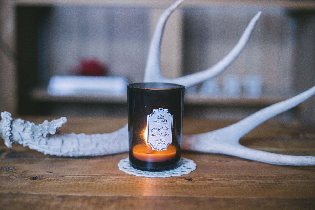 antler scented candle near deer horn rustic