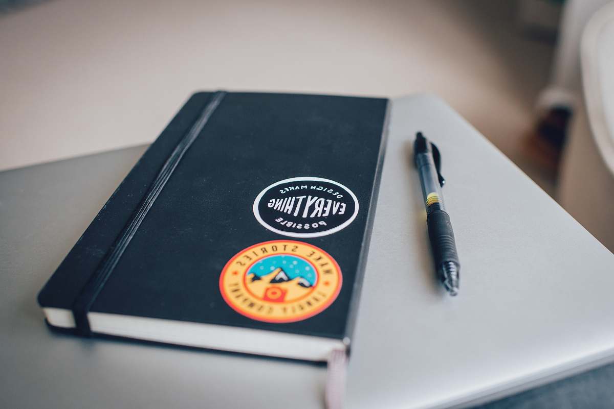 possible black book cover near black click pen notebook