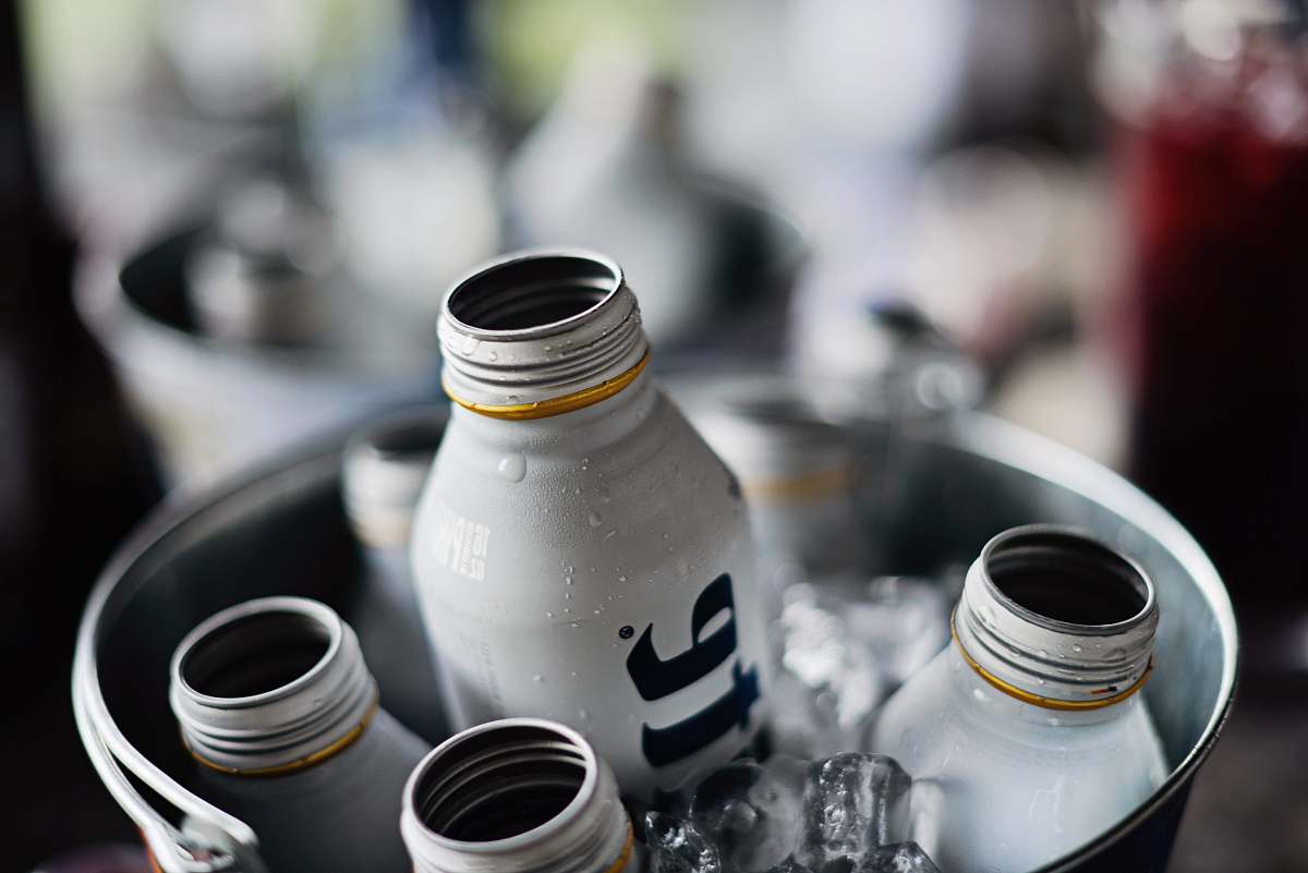alcohol shallow focus photography of liquor bottles inside a bucket filled with ice beer