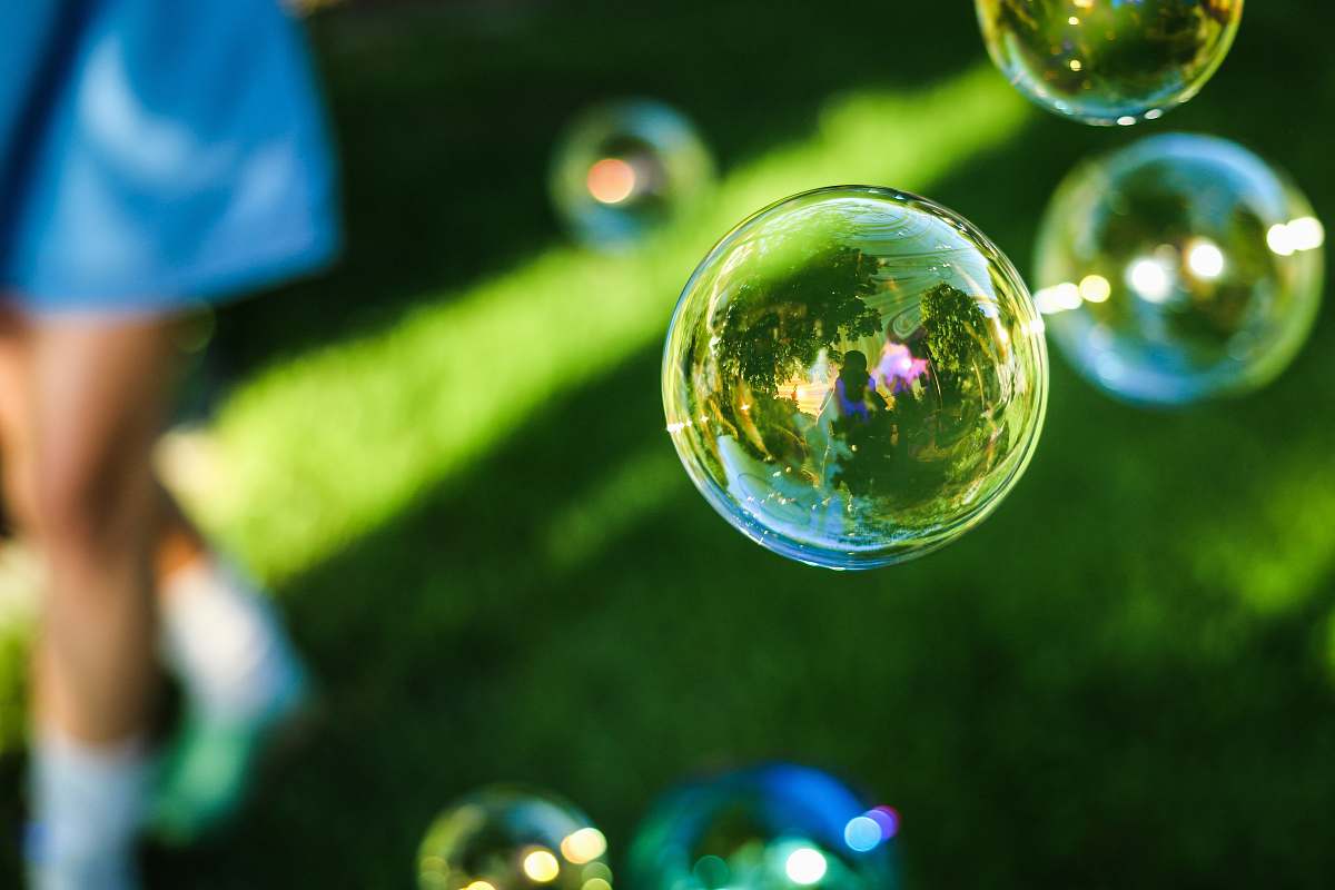 bubble person wearing blue shirt on green grass with bubbles bubbles